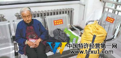 在济南东站候车厅内，老人带着自己的行李，孤独地等待着夜晚回程的列车。韩笑/摄